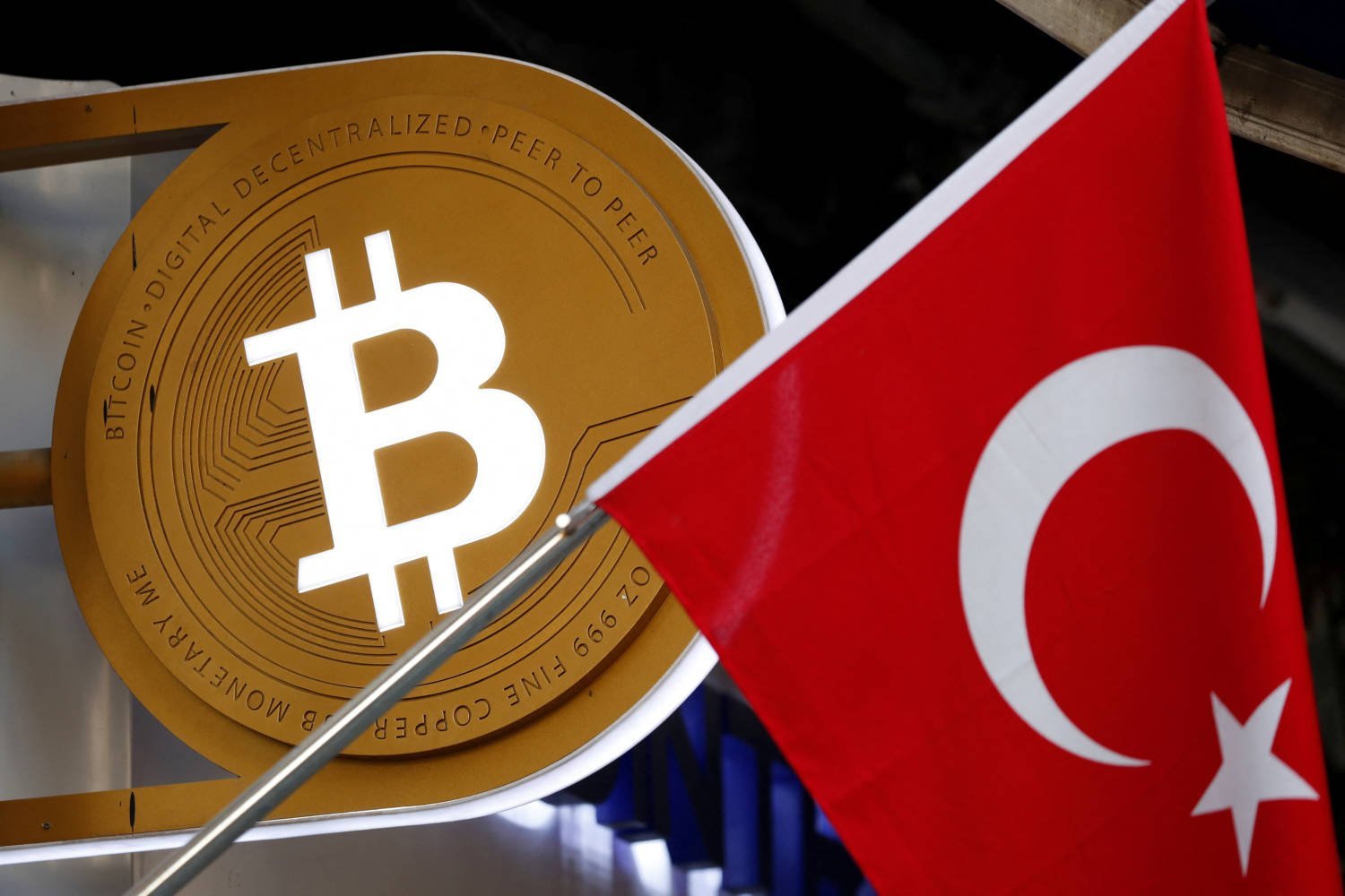 File Photo: A Bitcoin Logo Is Seen Next To Turkish Flag At A Cryptocurrency Exchange Shop In Istanbul