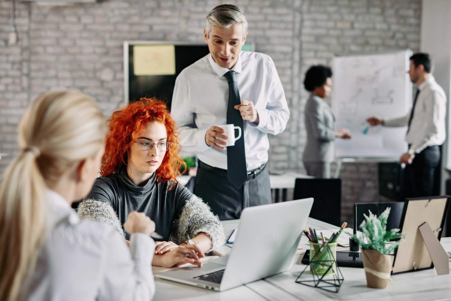 Young Businesswoman Using Computer While Having Meeting With Colleagues Office There Are People Background